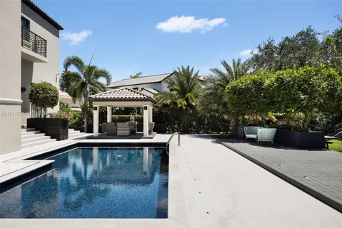 a view of house with swimming pool and a outdoor seating