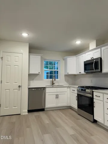 a large kitchen with stainless steel appliances granite countertop a stove and a sink