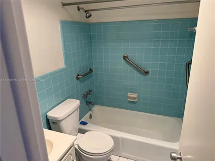 a white toilet and tub sitting next to a bathroom sink
