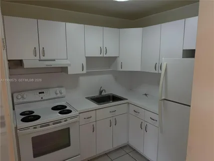 a kitchen with white cabinets and white appliances