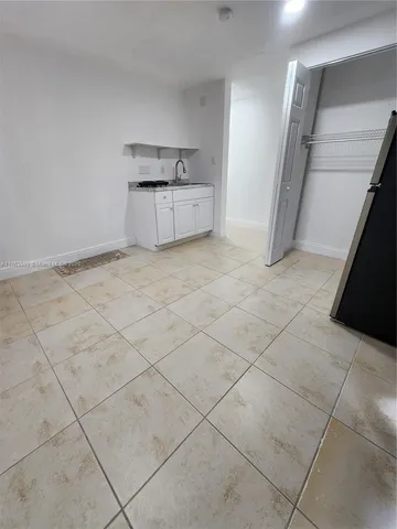 a view of a kitchen with white cabinets and a stove top oven