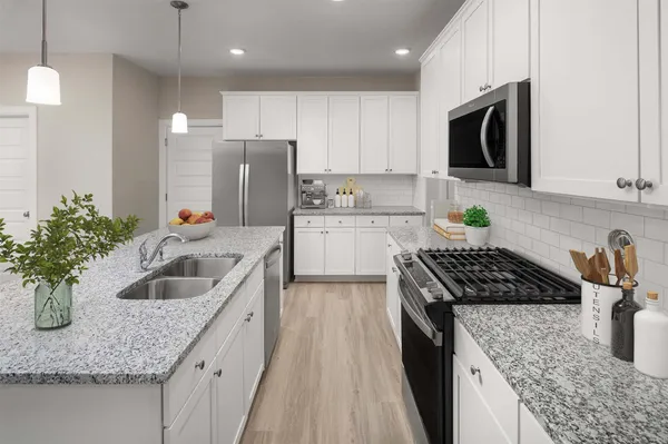 a kitchen with granite countertop stainless steel appliances sink stove and cabinets