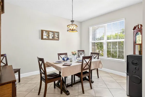 a kitchen with granite countertop a table chairs microwave and refrigerator