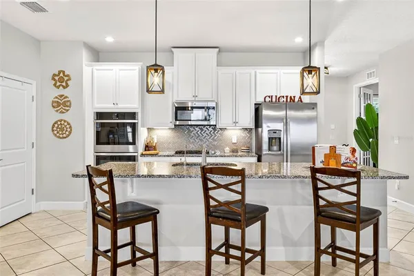 a kitchen with stainless steel appliances granite countertop a refrigerator and microwave