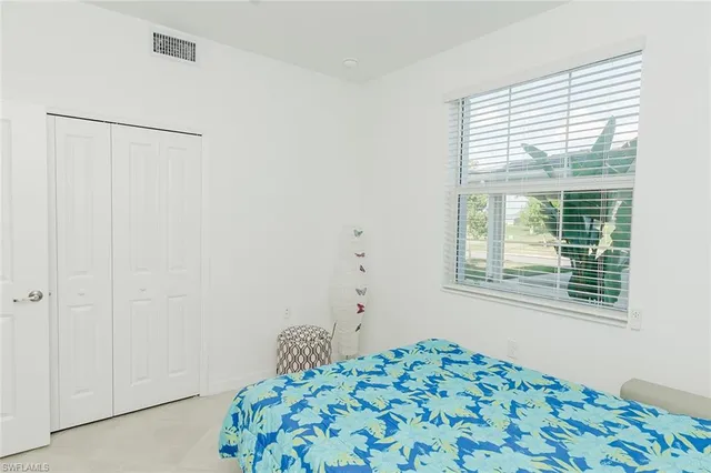 a bed sitting in a bedroom next to a window