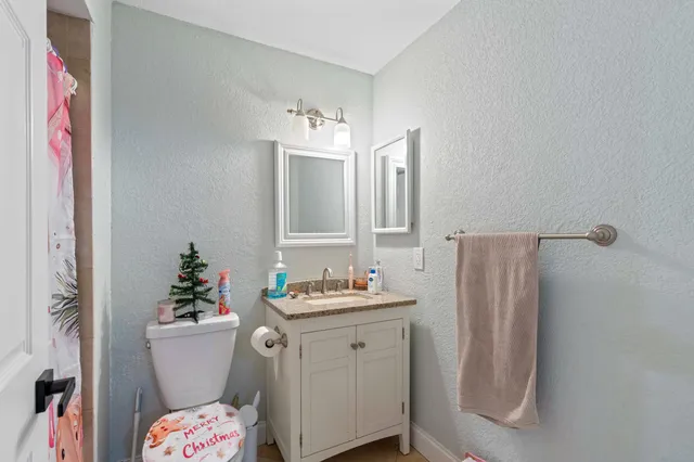 a bathroom with a sink vanity granite and toilet