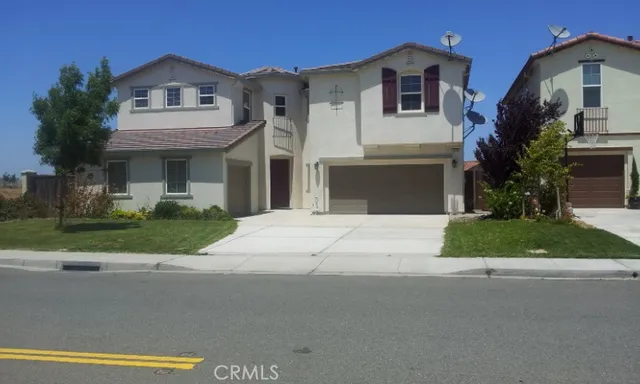 a front view of a house with a garden and garage