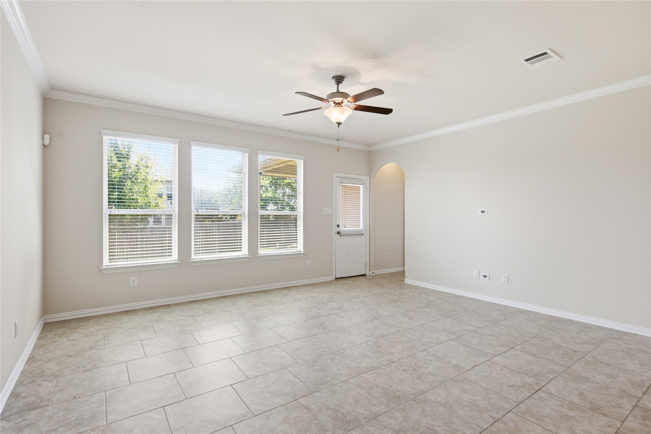 2601 Rough Berry Road Pflugerville, TX 78660 - Photo 16 of 36 A well-lit living area features tiled flooring and a convenient outdoor access door.