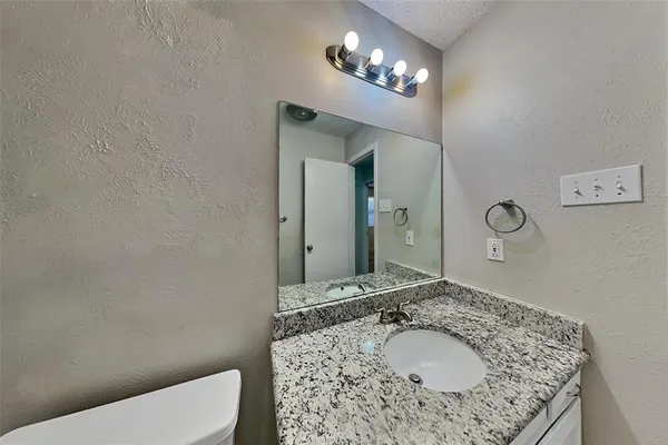 a bathroom with a sink a toilet and a mirror