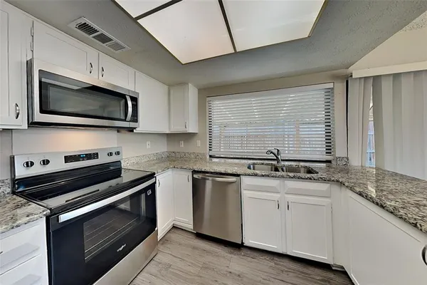 a kitchen with stainless steel appliances granite countertop a stove and a microwave