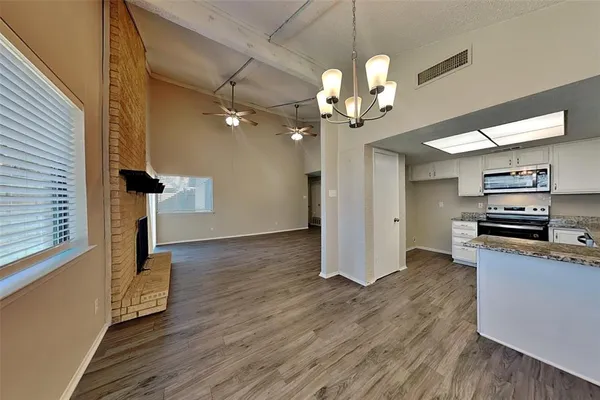 a view of a kitchen with wooden floor and a ceiling fan