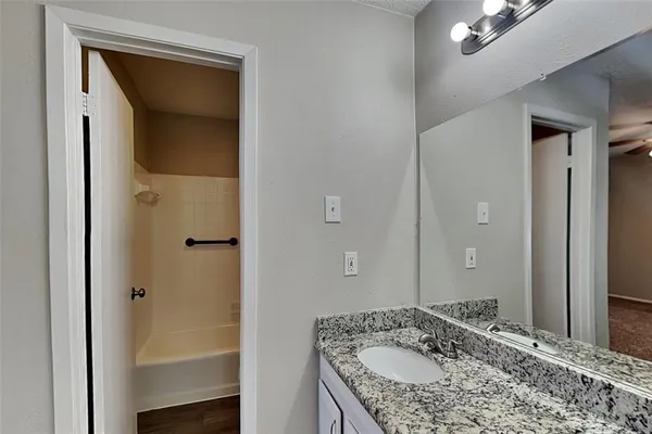 a bathroom with a granite countertop sink and a mirror
