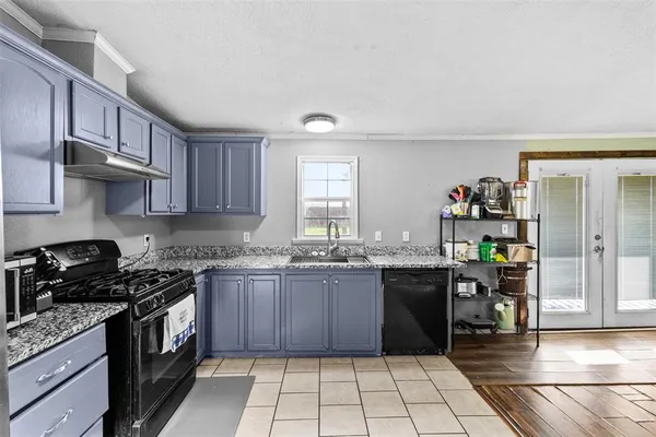 a kitchen with granite countertop a stove a sink and a cabinets