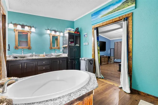 a bathroom with a tub a sink and mirror