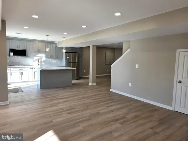 a view of kitchen with kitchen island wooden floor and center island
