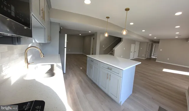 a kitchen with a sink and wooden floor