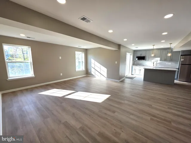 a view of empty room with wooden floor and window