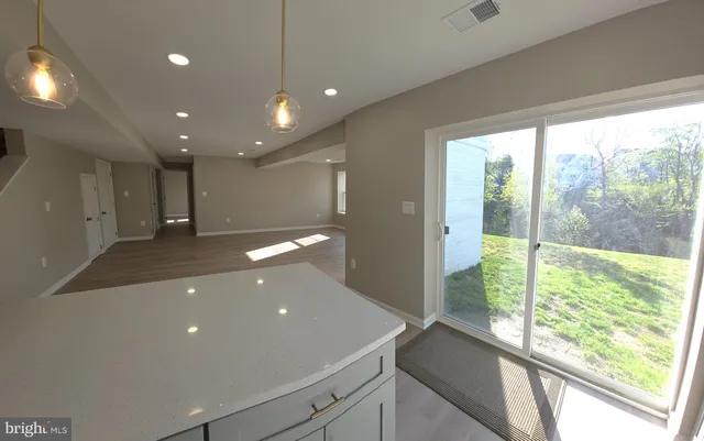 a view of an empty room with wooden floor and a floor to ceiling window