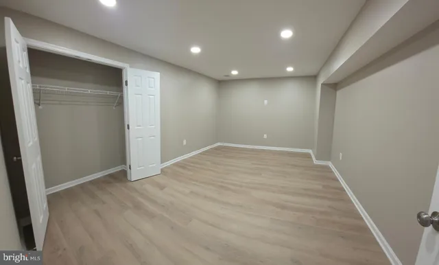an empty room with wooden floor and entrance