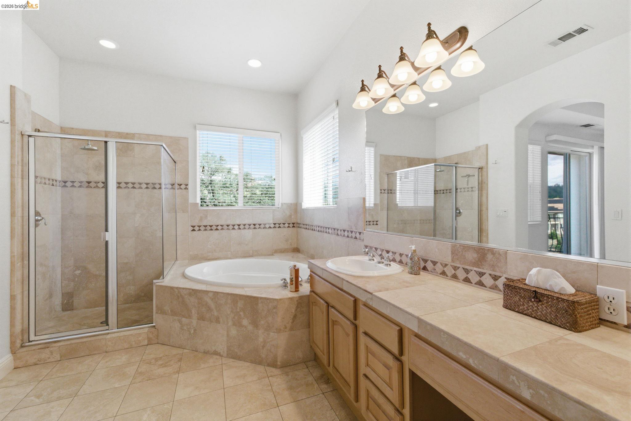 32 Apollo Lane Copperopolis, CA 95228 - Photo 28 of 58 Bathroom with vanity, a stall shower, a garden tub, light tile patterned floors, and recessed lighting