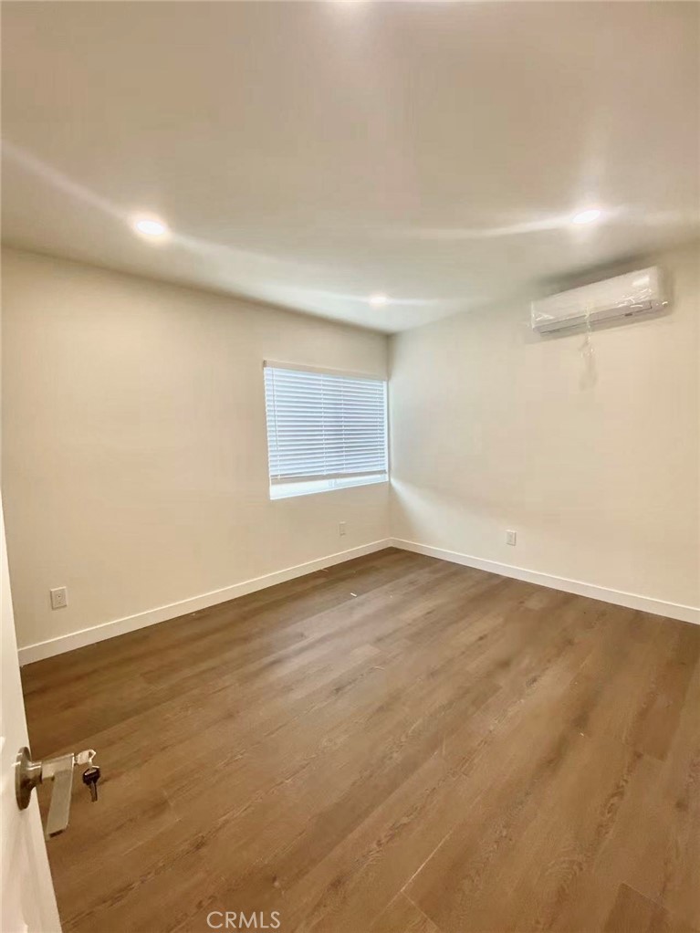 920 West Olive Avenue, Unit 1 Monrovia, CA 91016 - Photo 11 of 13 an empty room with wooden floor and windows