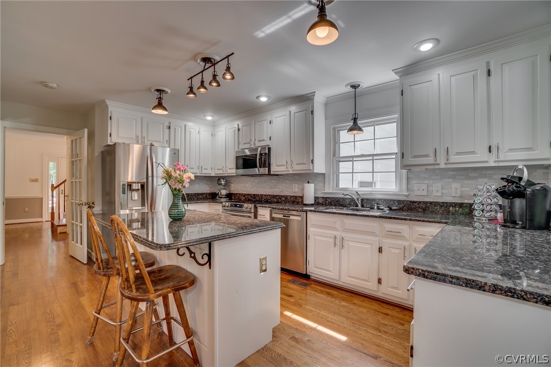 13131 Drakewood Road Midlothian, VA 23113 - Photo 11 of 29 a kitchen with kitchen island stainless steel appliances a sink a stove a refrigerator cabinets and living room view
