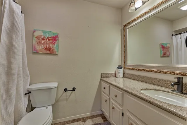 a bathroom with a granite countertop sink a mirror and shower