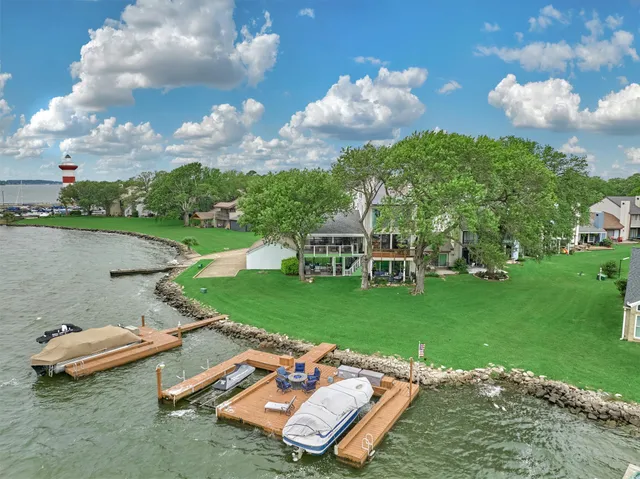an aerial view of a house with a yard and lake view