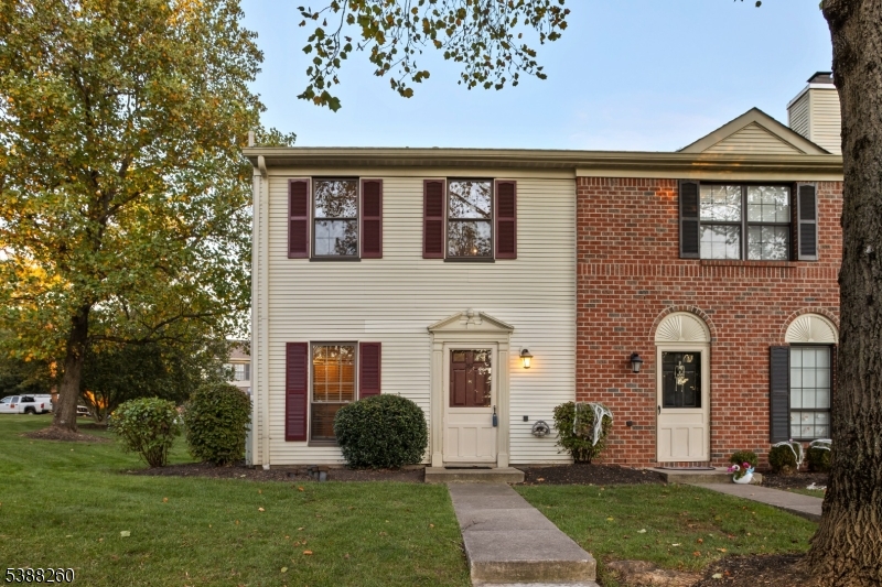 a front view of a house with a yard and trees