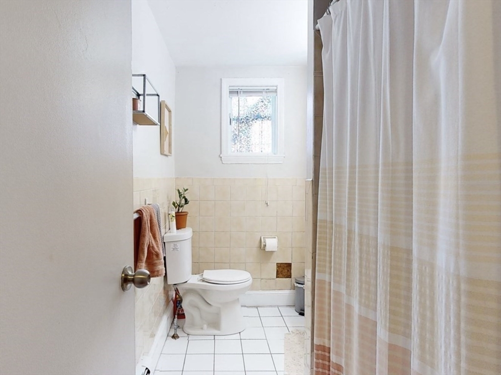 32 South Huntington Avenue, Unit 1 Boston, MA 02130 - Photo 15 of 17 a white toilet sitting next to a shower curtain