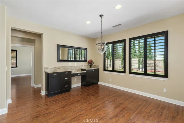 a large kitchen with wooden floor and stainless steel appliances