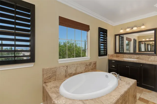 a bathroom with a tub sink and mirror