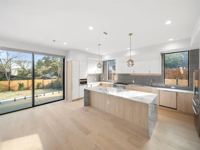 a large white kitchen with a large window