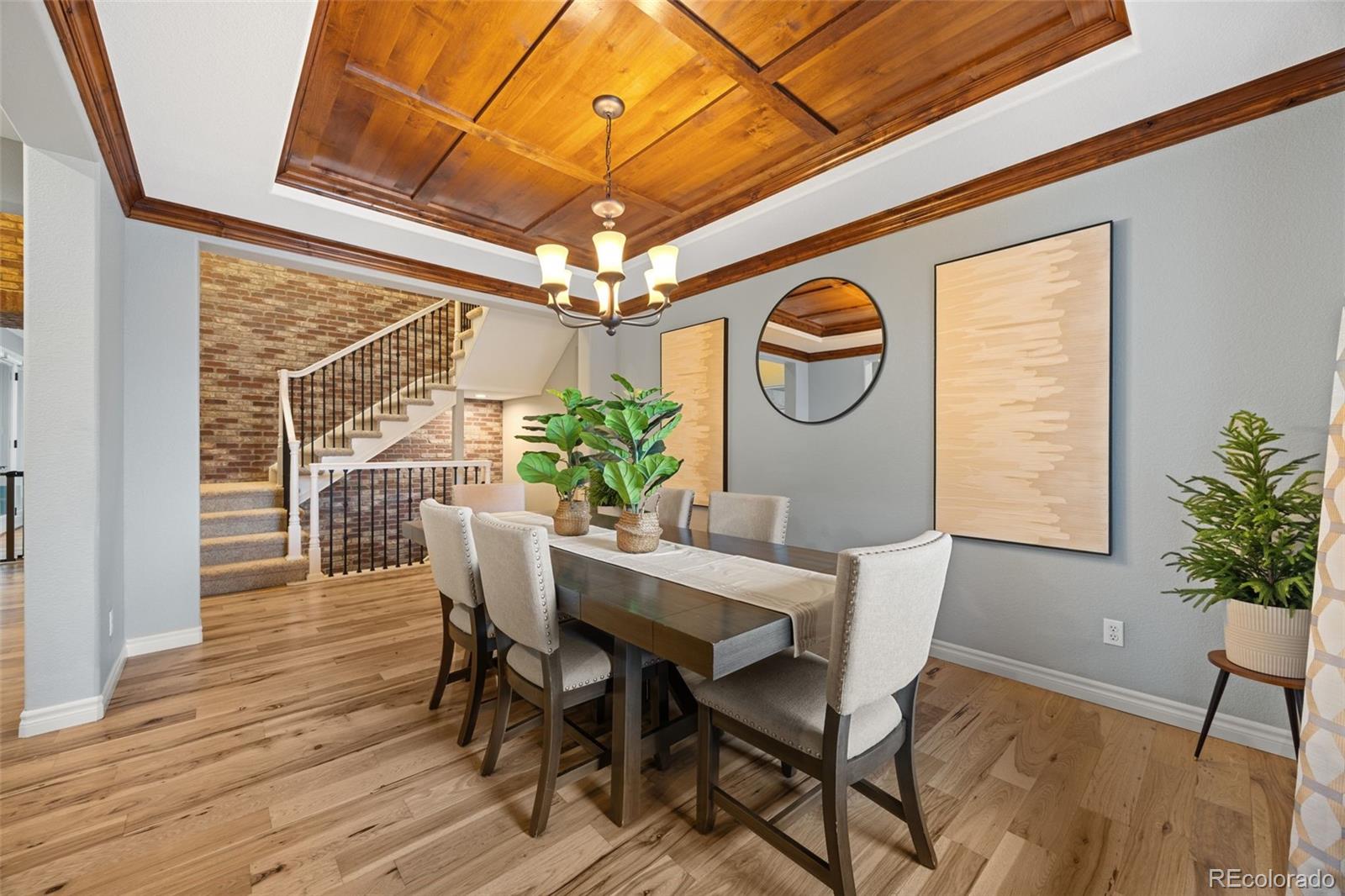 10466 Marigold Court Highlands Ranch, CO 80126 - Photo 2 of 50 a dining room with furniture a chandelier and wooden floor