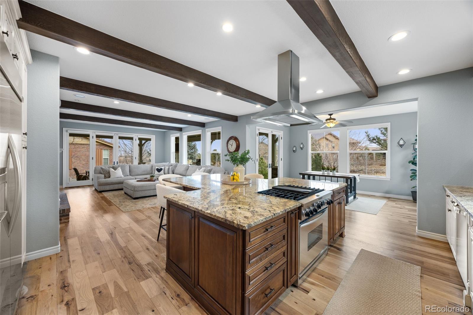 10466 Marigold Court Highlands Ranch, CO 80126 - Photo 9 of 50 a kitchen with stainless steel appliances granite countertop a stove and a wooden floors