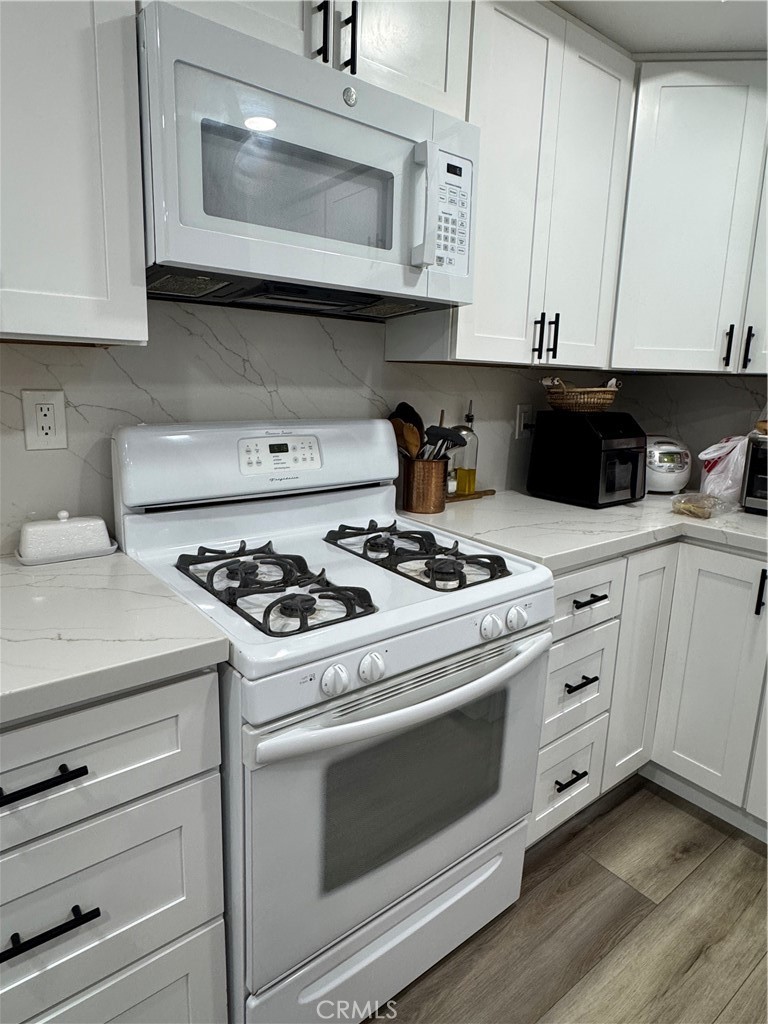 682 East Workman Street Covina, CA 91723 - Photo 12 of 36 a kitchen with granite countertop white cabinets and appliances
