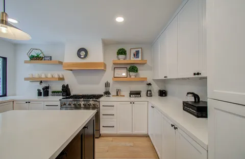 a kitchen with stainless steel appliances a sink a stove and cabinets