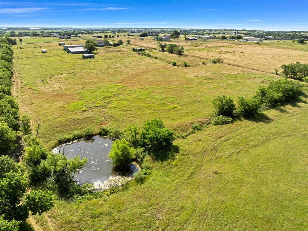 1795 Melton Road Sanger, TX 76266 - Photo 15 of 17 Expansive acreage featuring a natural pond, surrounding greenery, and open fields