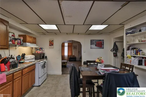 a kitchen with stainless steel appliances granite countertop a stove a refrigerator a dining table and chairs with white cabinets