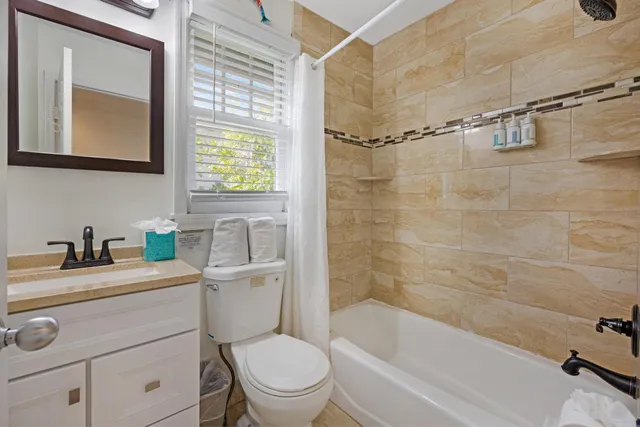 a bathroom with a granite countertop sink toilet a mirror and shower