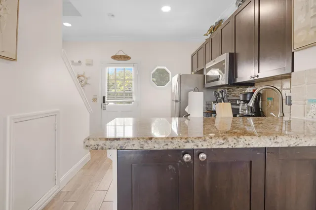 a kitchen with granite countertop a sink a stove and cabinets
