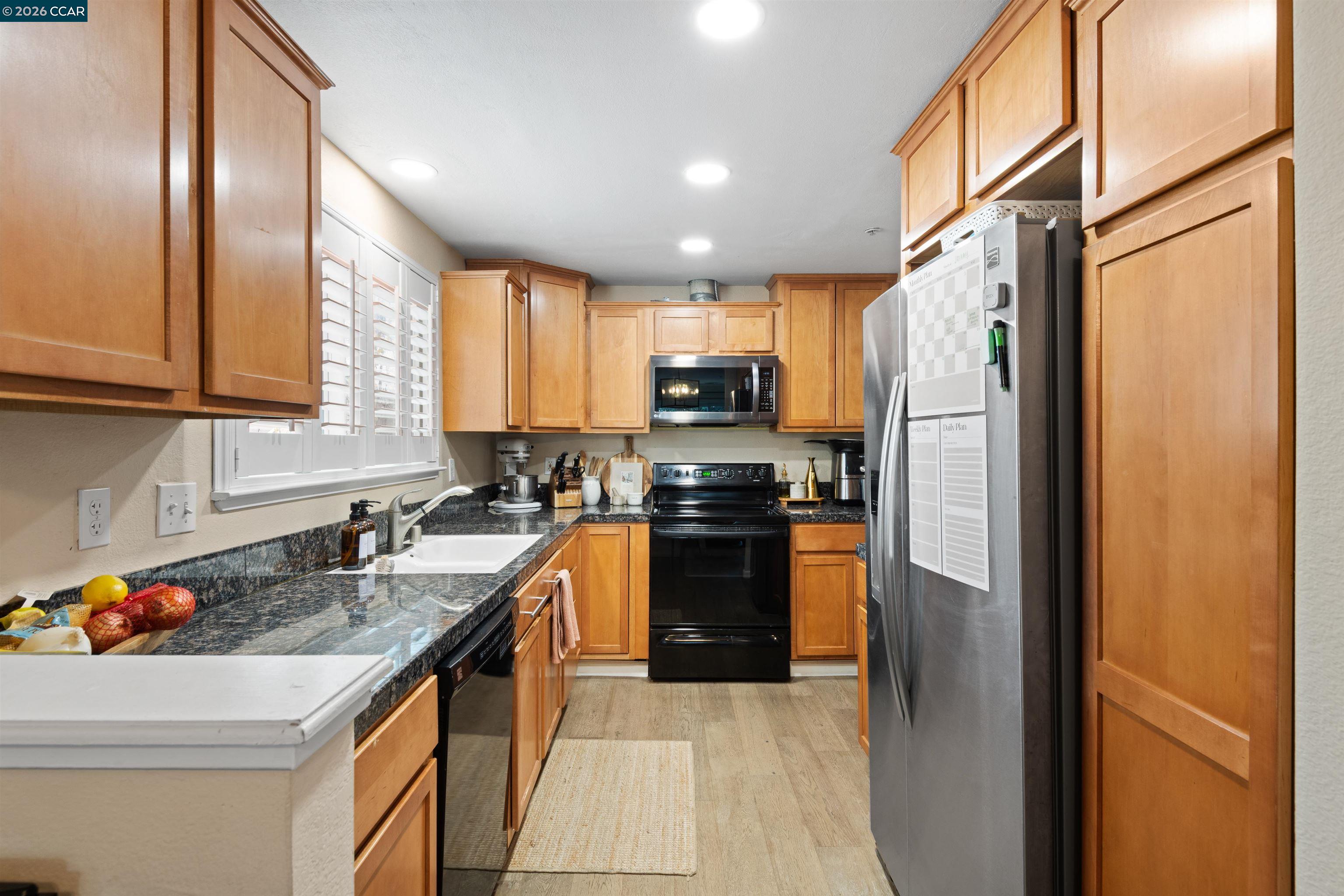 2721 Oak Road, Unit L Walnut Creek, CA 94597 - Photo 6 of 25 a kitchen with a refrigerator a sink a stove and cabinets