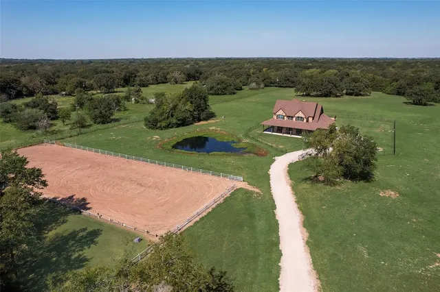 an aerial view of a house with yard basket ball court and outdoor seating
