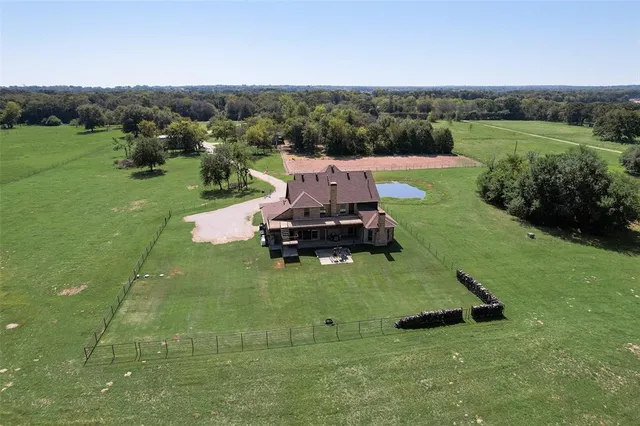 an aerial view of residential houses with outdoor space and trees