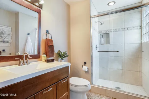 a bathroom with a sink a toilet and shower