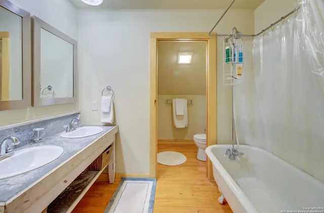 a bathroom with a granite countertop sink a mirror a bathtub and shower