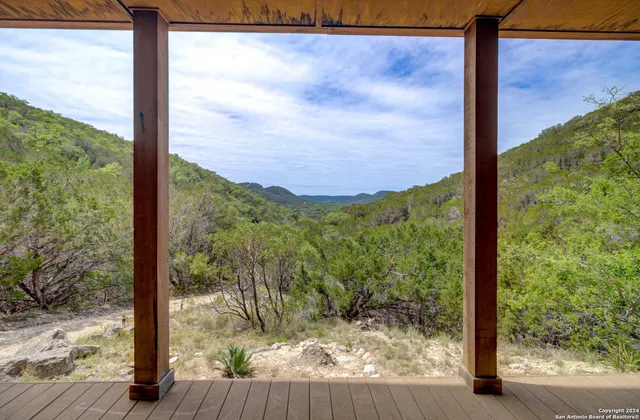 a view of a room with a large window and wooden floor