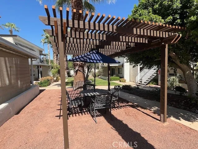 a view of a patio with table and chairs with wooden floor and fence