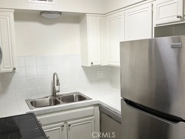 a close view of a sink and refrigerator in kitchen