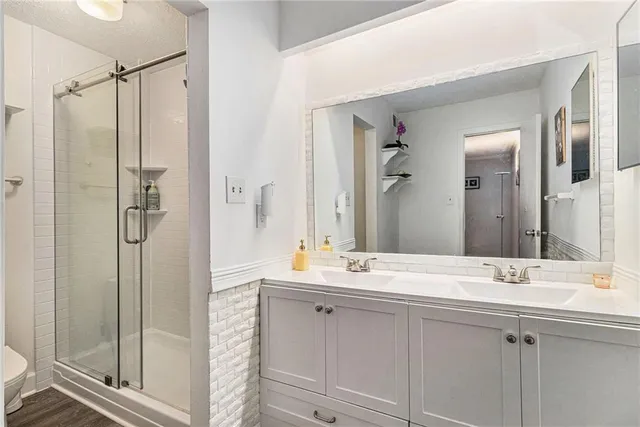 a bathroom with a double vanity sink mirror and shower